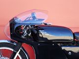 a black and red motorcycle parked in front of a pink wall