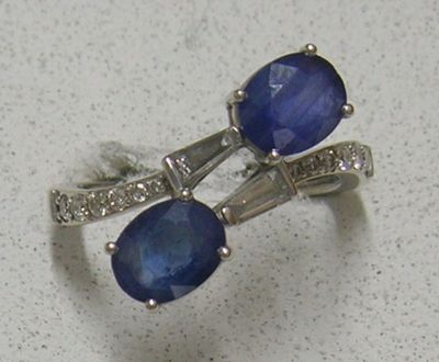 une paire de boucles d'oreilles en saphir bleu et diamants sur un fond blanc