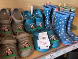 Plusieurs paires de chaussures pour enfants sont posées sur une étagère dans un magasin.