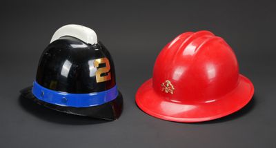 une paire de casques de pompier rouges et noirs sur fond noir