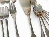 a lot of silver spoons and forks on the table