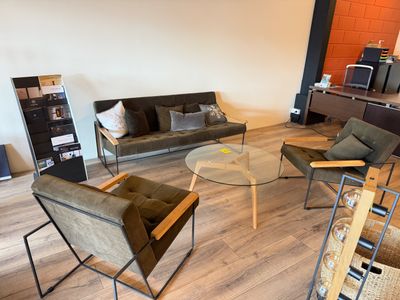 un salon avec des canapés, des fauteuils et une table basse