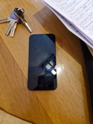 un téléphone portable posé sur une table à côté d'un trousseau de clés