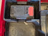 a red tool box with a drill and a battery in it