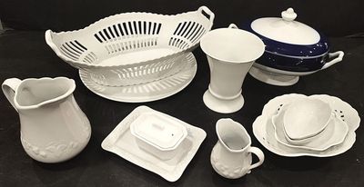 a lot of white dishes and cups on a black table
