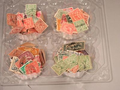 de nombreux timbres de toutes sortes dans une boîte en plastique posée sur une table
