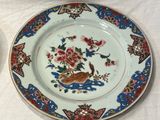 a plate with a bird and flowers on it next to a plate with a bird and flowers on it