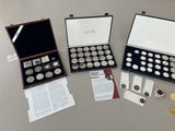 three silver and gold coins are in a case on a table