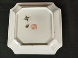 a white plate with a bird on it on a table