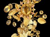 broche en forme de fleur plaquée or, ornée de cristaux et de feuilles sur fond noir
