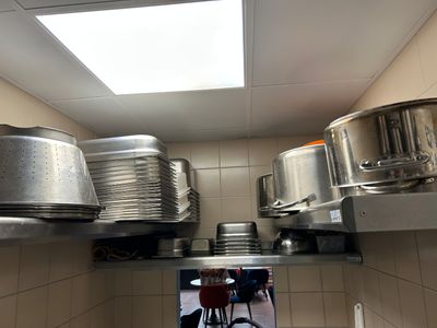 de nombreuses casseroles et poêles sur les étagères de la cuisine