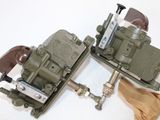 two toy army vehicles sitting on a white surface