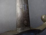 a close up of a sword with a wooden handle