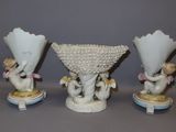 three porcelain figurines of cherenshes and cherenshes on pedestals