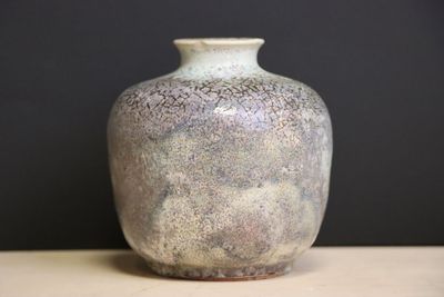 a vase that is sitting on a table with a black background