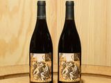 deux bouteilles de vin posées l'une à côté de l'autre sur un tonneau