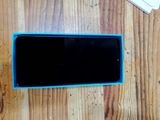 a cell phone sitting on a wooden table next to a keyboard