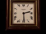 a small clock with roman numerals on the face