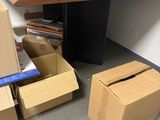 a pile of boxes sitting on the floor next to a desk