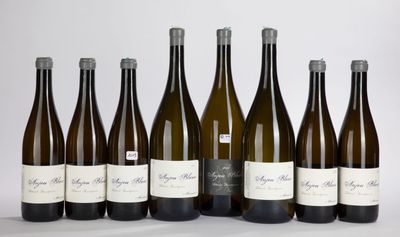 six bottles of wine are lined up in a row on a white surface