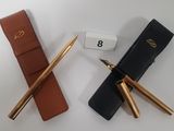 two pens and a pen case next to each other