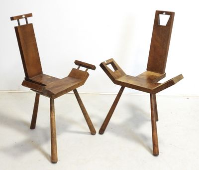 two wooden chairs sitting next to each other on a white floor