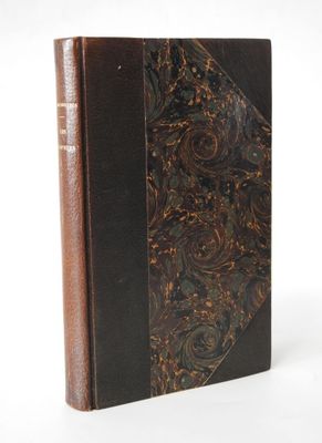 an old book with a brown cover sitting on top of a white surface