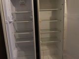 two open refrigerators in a kitchen with a blue wall behind them