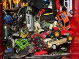 a red box filled with toy cars and other toys