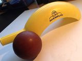 une banane et une balle rouge posées sur une table