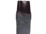 a black vase that is sitting on a white surface