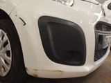 a close up of the front of a white car in a garage