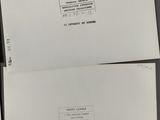 three white envelopes are sitting on top of each other
