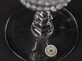 a glass of wine with a coin on the bottom