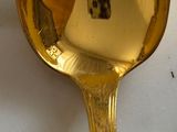 a gold spoon with a picture of a person on it