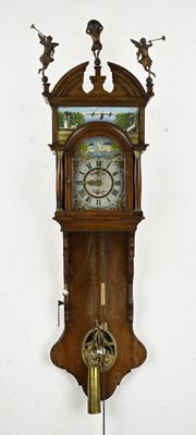 a clock that is hanging on the wall with angels on it