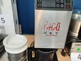 a coffee maker that is sitting on a table next to a cup