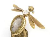 an image of a gold dragonfly broochle with a stone in it