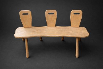un banc en bois sur lequel sont posées trois chaises