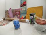 a table with a roll of paper, a candle, a cup, and other items on it