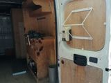 a white van with a wooden door open in the woods