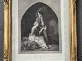 a framed picture of a woman sitting on a bed next to a dog