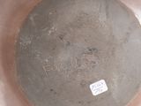 a silver vase with a brown base and a tag on it