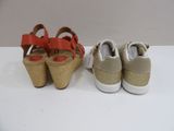 two pairs of women ' s shoes with cork soles on a white surface