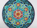 une assiette décorée d'un motif coloré, posée sur une table