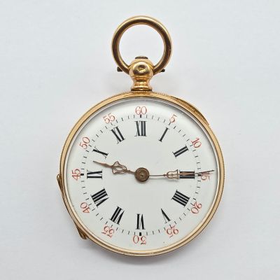 une montre de poche en or avec des chiffres romains sur le cadran