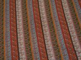 a close up of a striped blanket on a bed