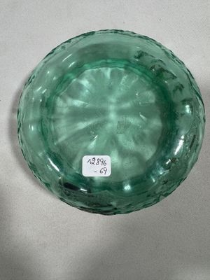 a green glass bowl sitting on a white table