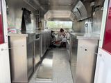 a woman standing in the kitchen of a food truck