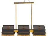 three black and gold boxes on a wooden stand with a bird on top